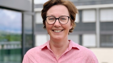 Eline Paxal smilende med briller og rosa skjorte