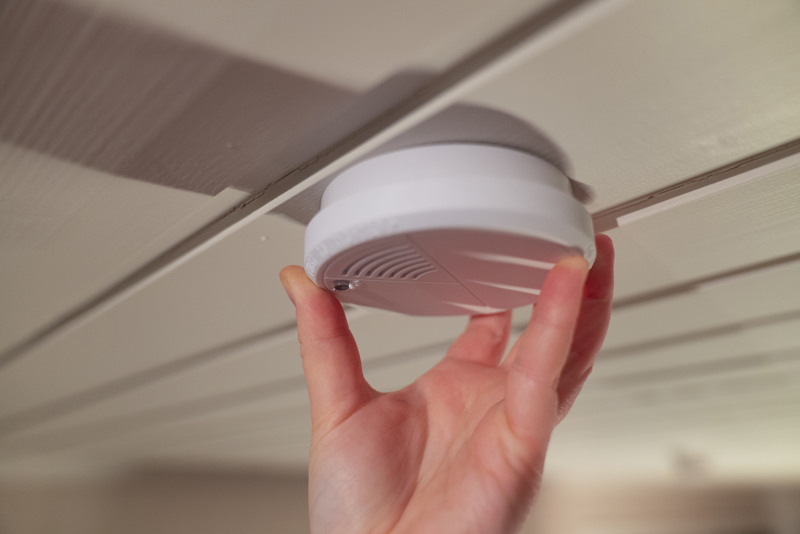 Hånd som skrur på en røykvarsler