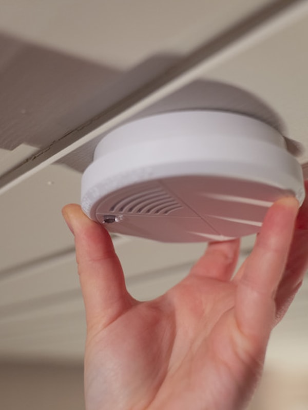 Hand turning on a smoke detector