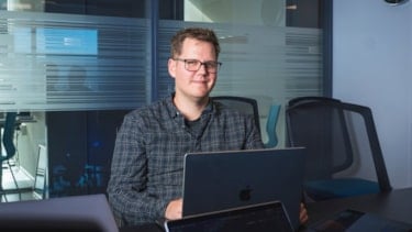 Karl-Einar sittende foran en tv-skjerm i et kontorlokale