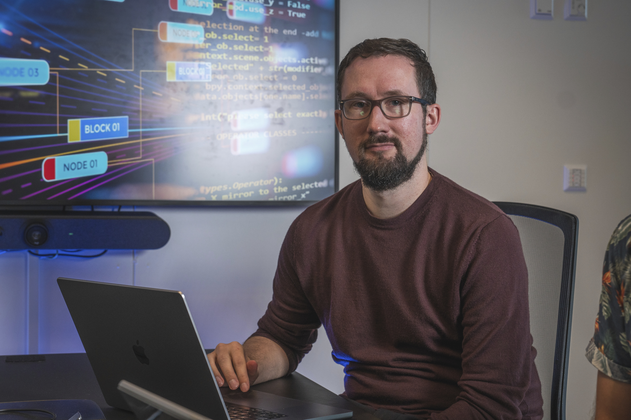 Tommy Ballestad foran pc-skjerm med lys og fargerike elementer