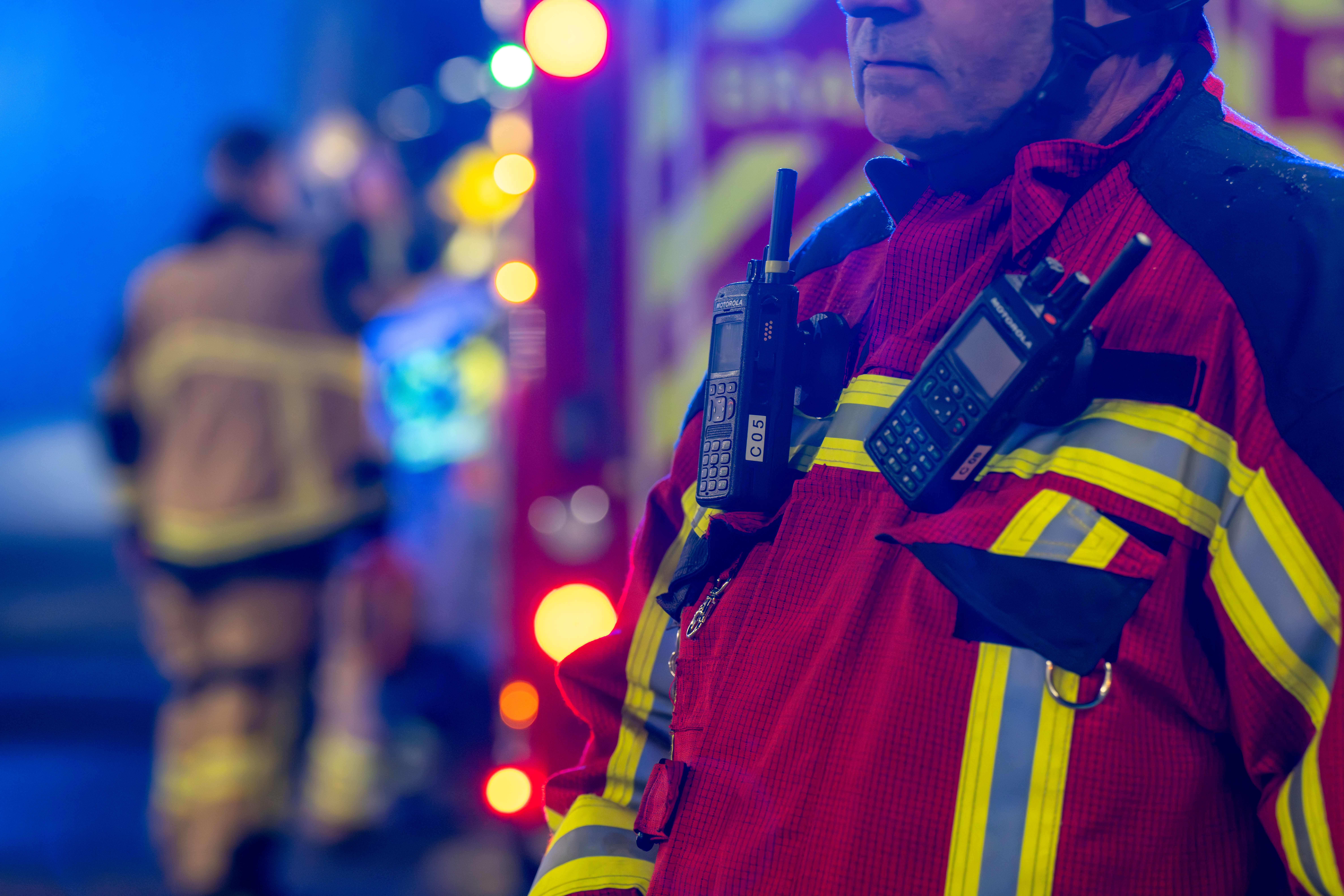 Nærbilde av brannkonstabel med radioterminaler på brystet under øvelse i tunnel.