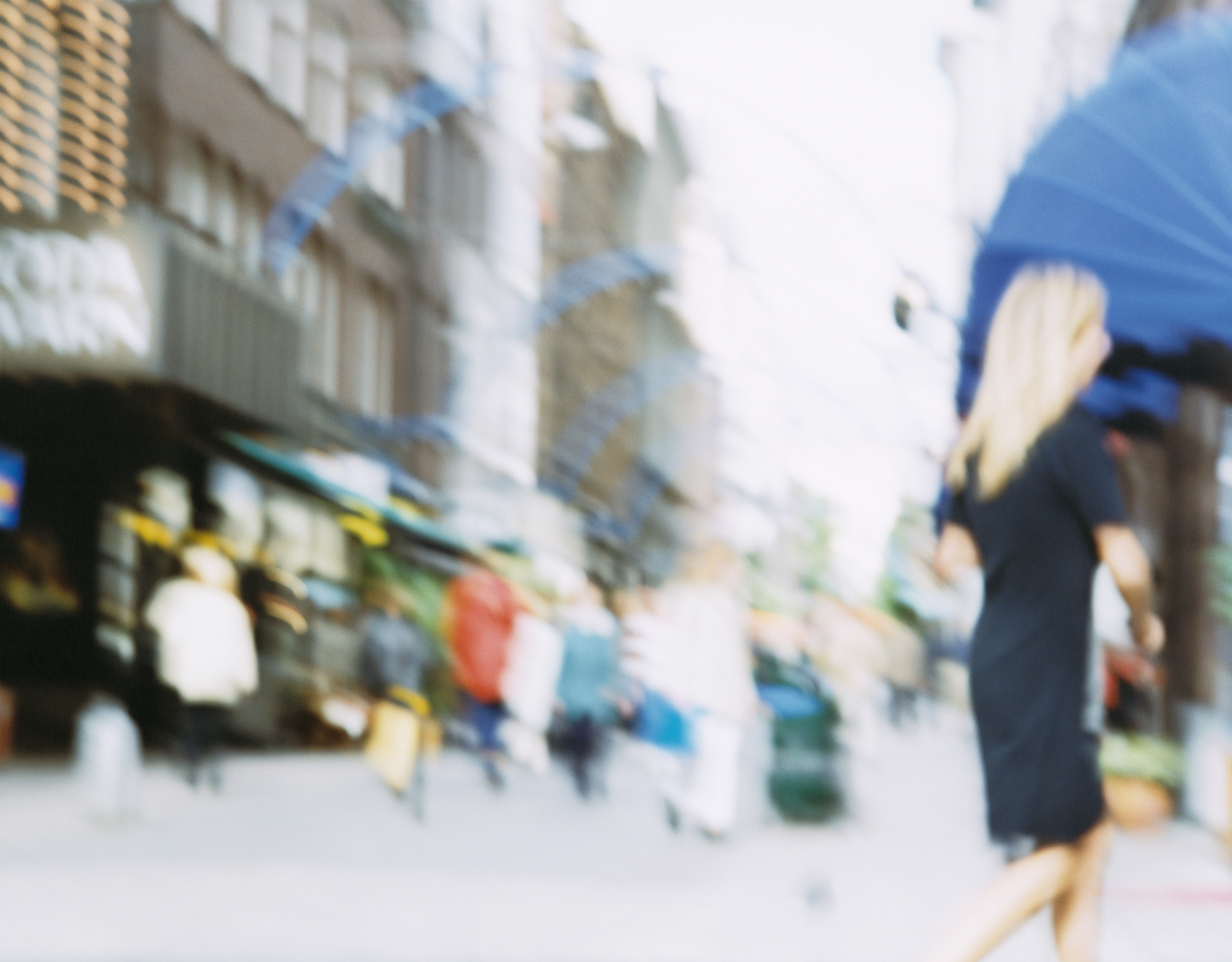 Street with people on the move. The image is blurry.