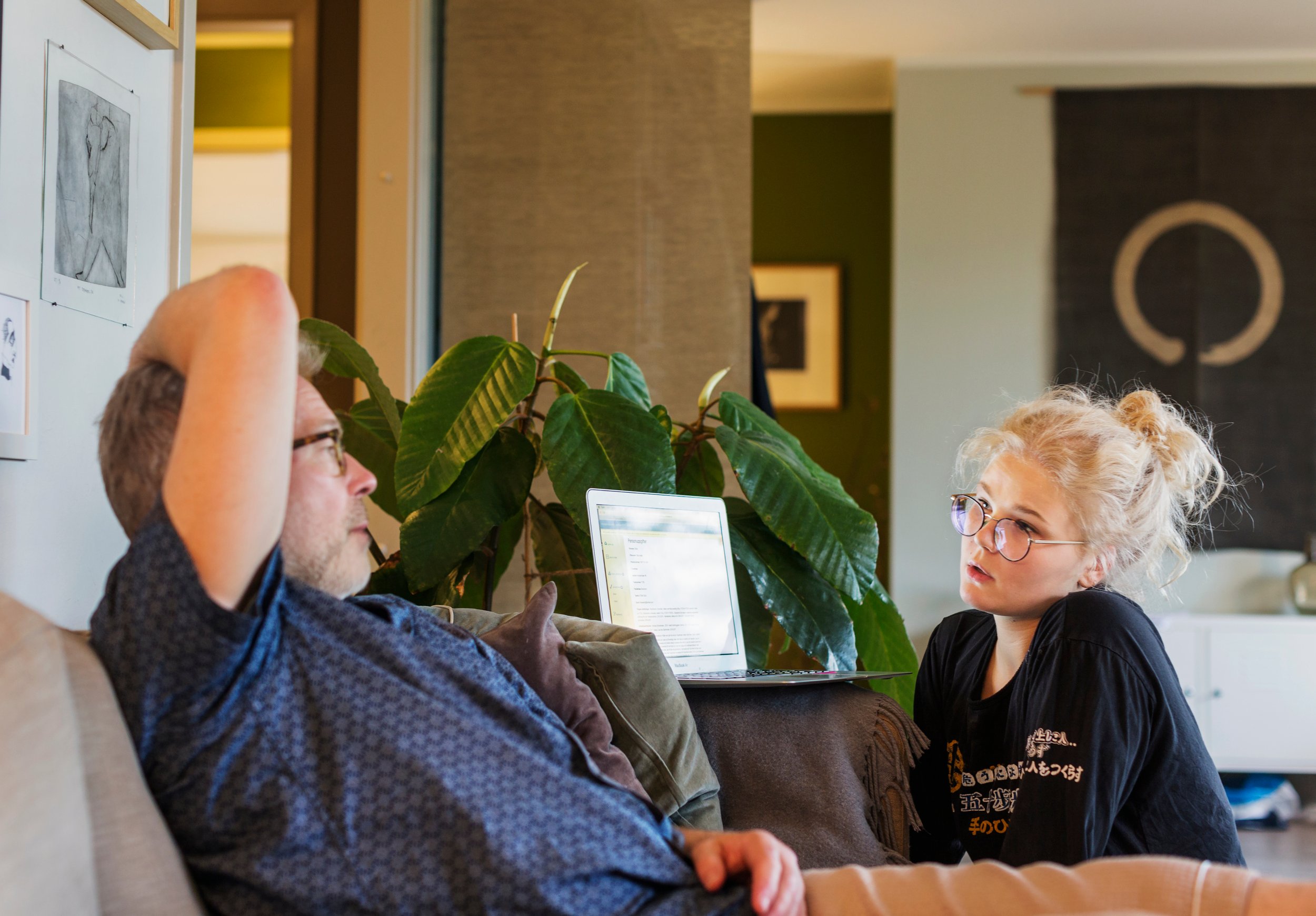 Ei ung ung jente pratar med ein vaksen i ei stue. 