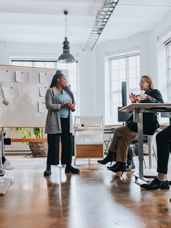 Gruppe mennesker som står foran en tavle og snakker