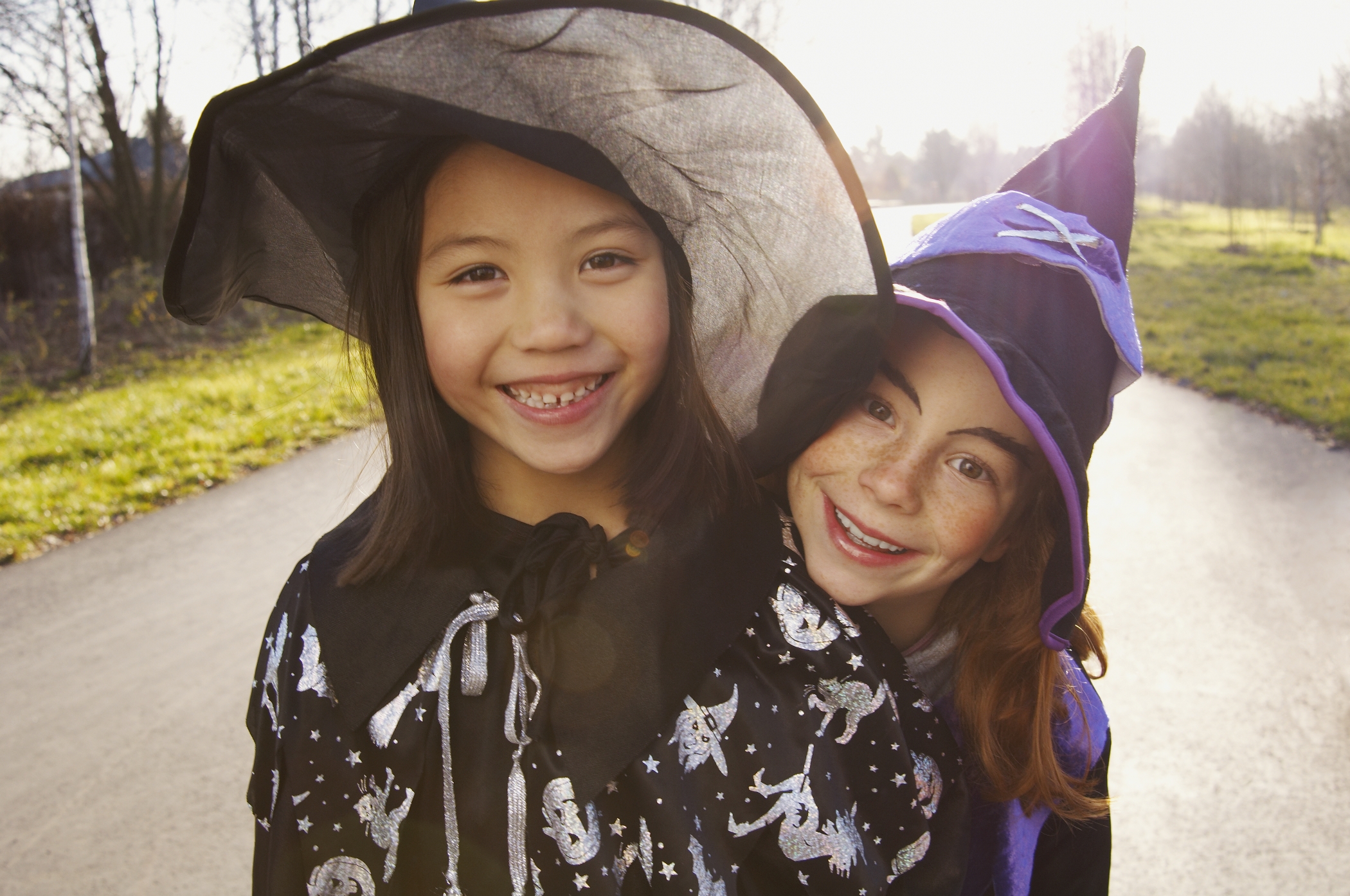 Two smiling girls dressed up in witch costumes