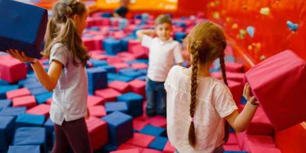 Barn som leker med skumgummiklosser i et lekeland