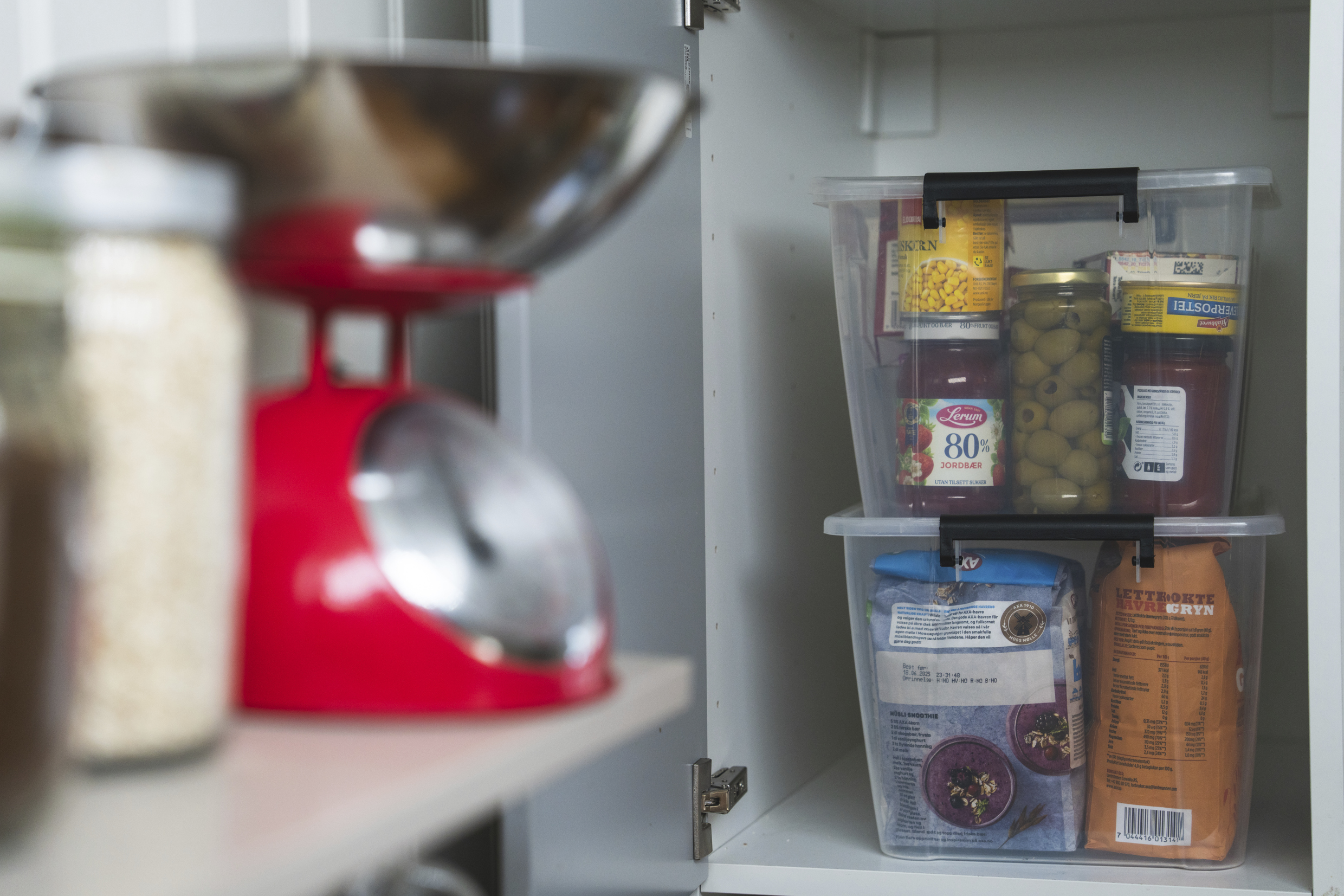 Mann som holder en liten jente på armen mens han skyver en handlevogn full med varer foran seg. På siden går det to unge gutter som bærer en vannkanne og en lykt.