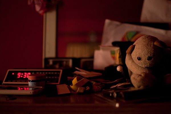 Mørkt rom med medisiner og en bamse på nattbordet