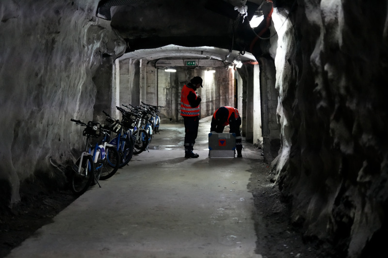 Sivilforsvarsmannskaper inne i mørk tunnel mot et tilfluktsrom