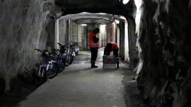 Sivilforsvarsmannskaper inne i mørk tunnel mot et tilfluktsrom