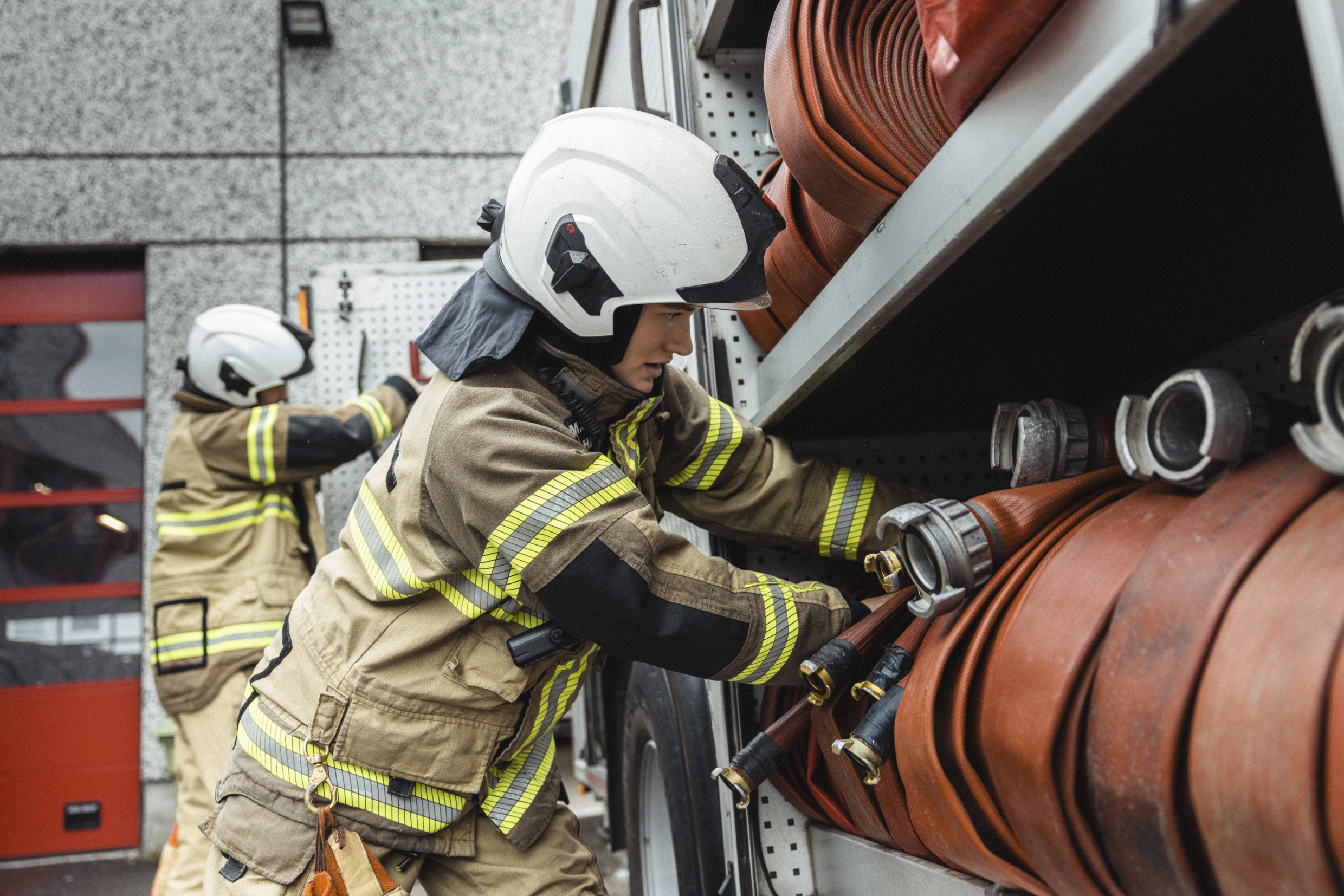 Brannkonstabler holder på med brannslanger.