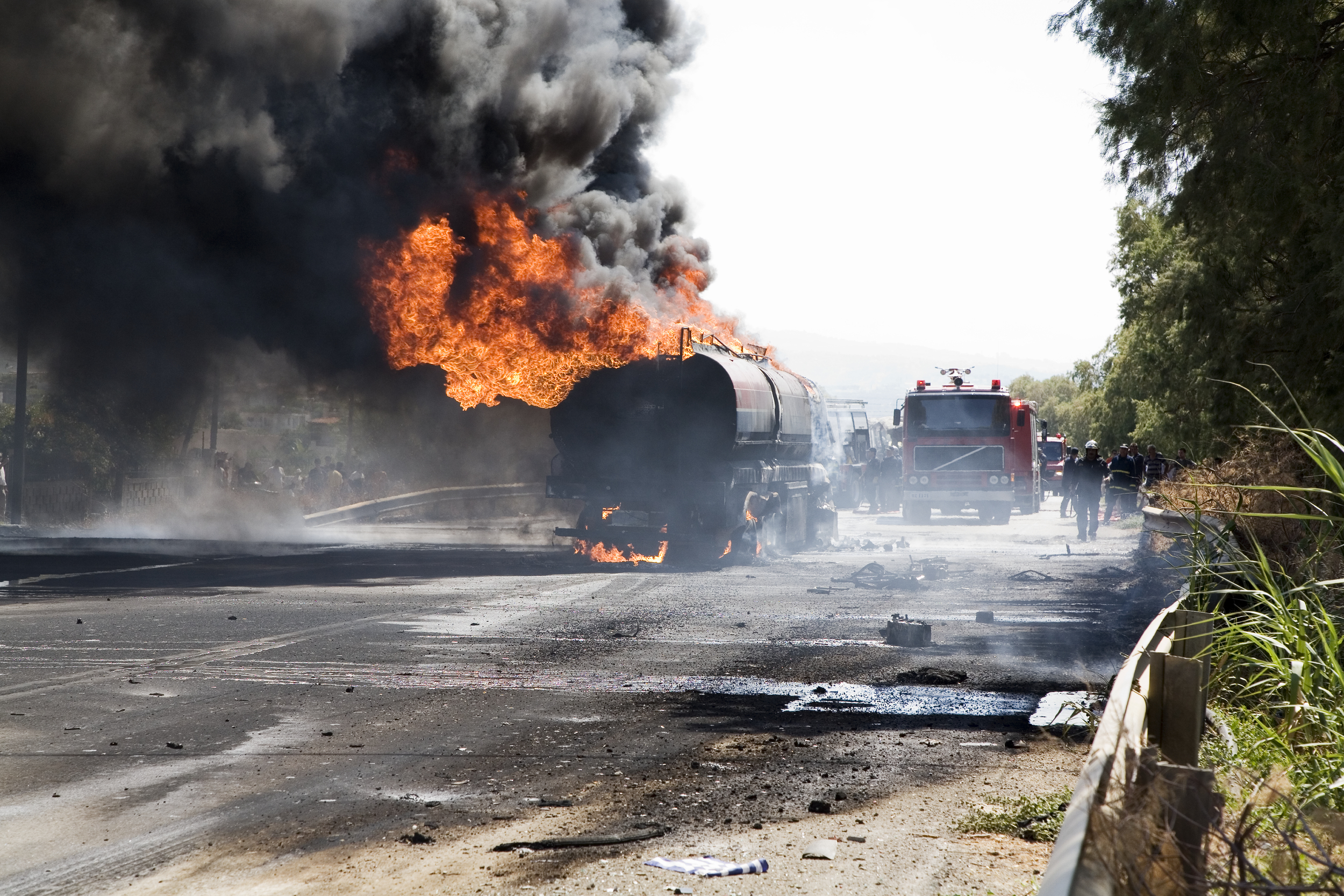 Tank car burning with large flames and black smoke.