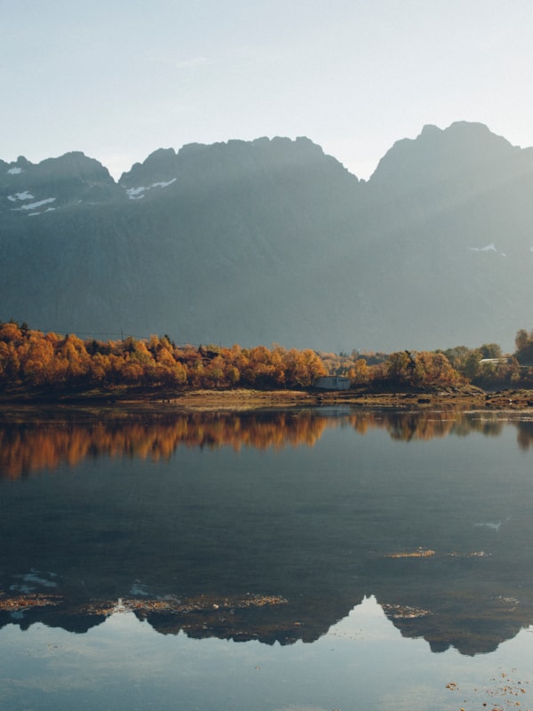 Fjell som speiler seg i stille vann