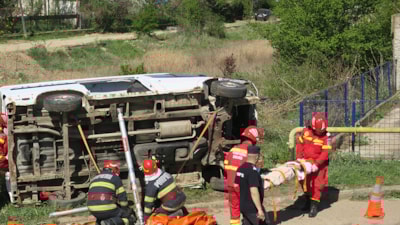 Redningspersonell ved siden av en veltet bil