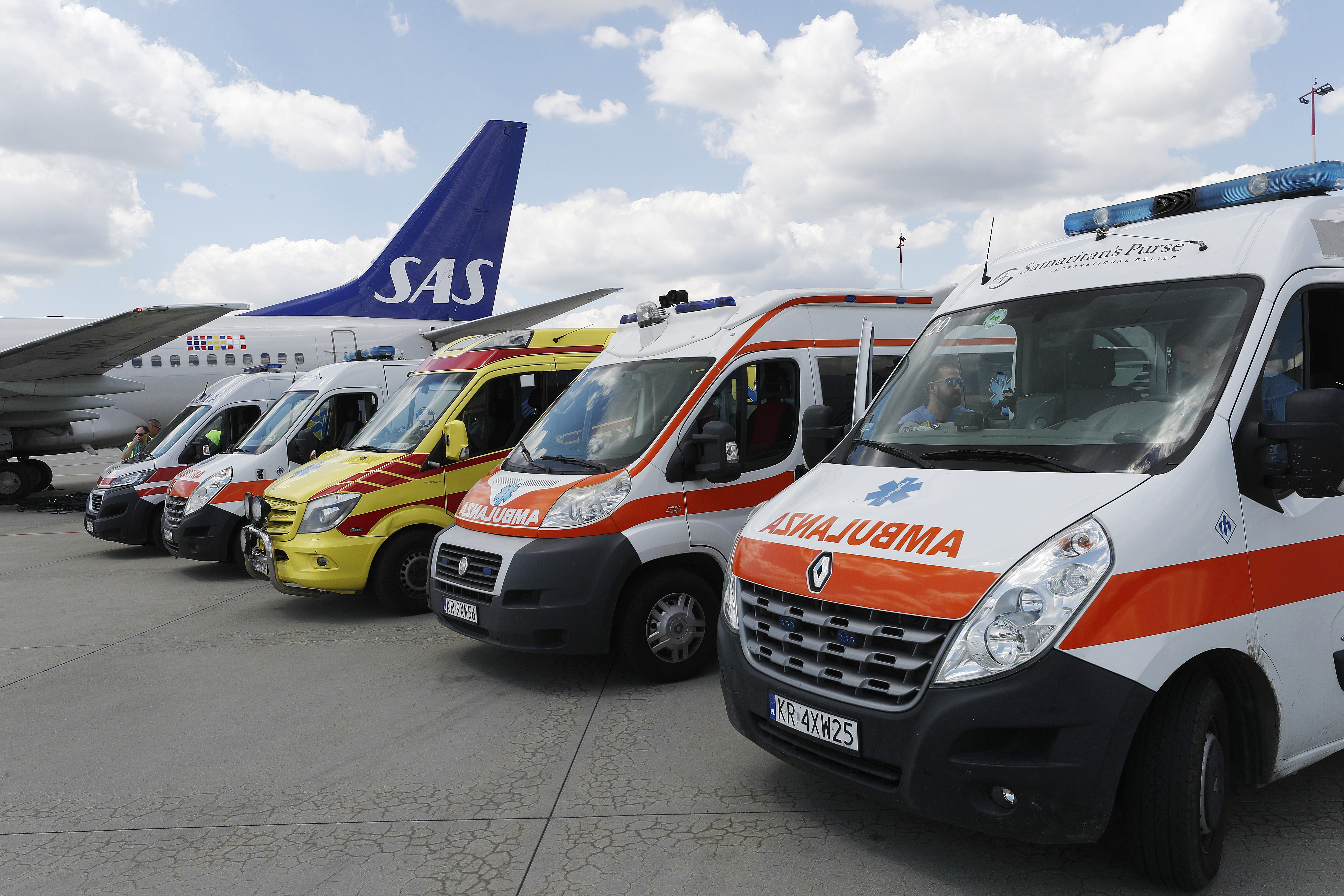 Utrykningskjøretøy parkert på linje sammen med et ambulansefly