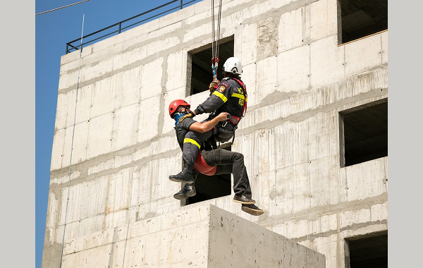 Redningsarbeidere som henger fra wire mellom bygninger