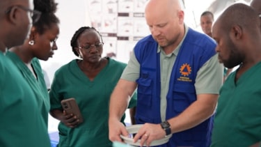 Helsepersonell som setter opp medisinsk utstyr.