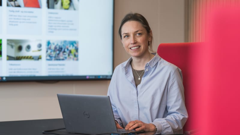 Ane Bjørtuft sittende bak en pc ved et bord