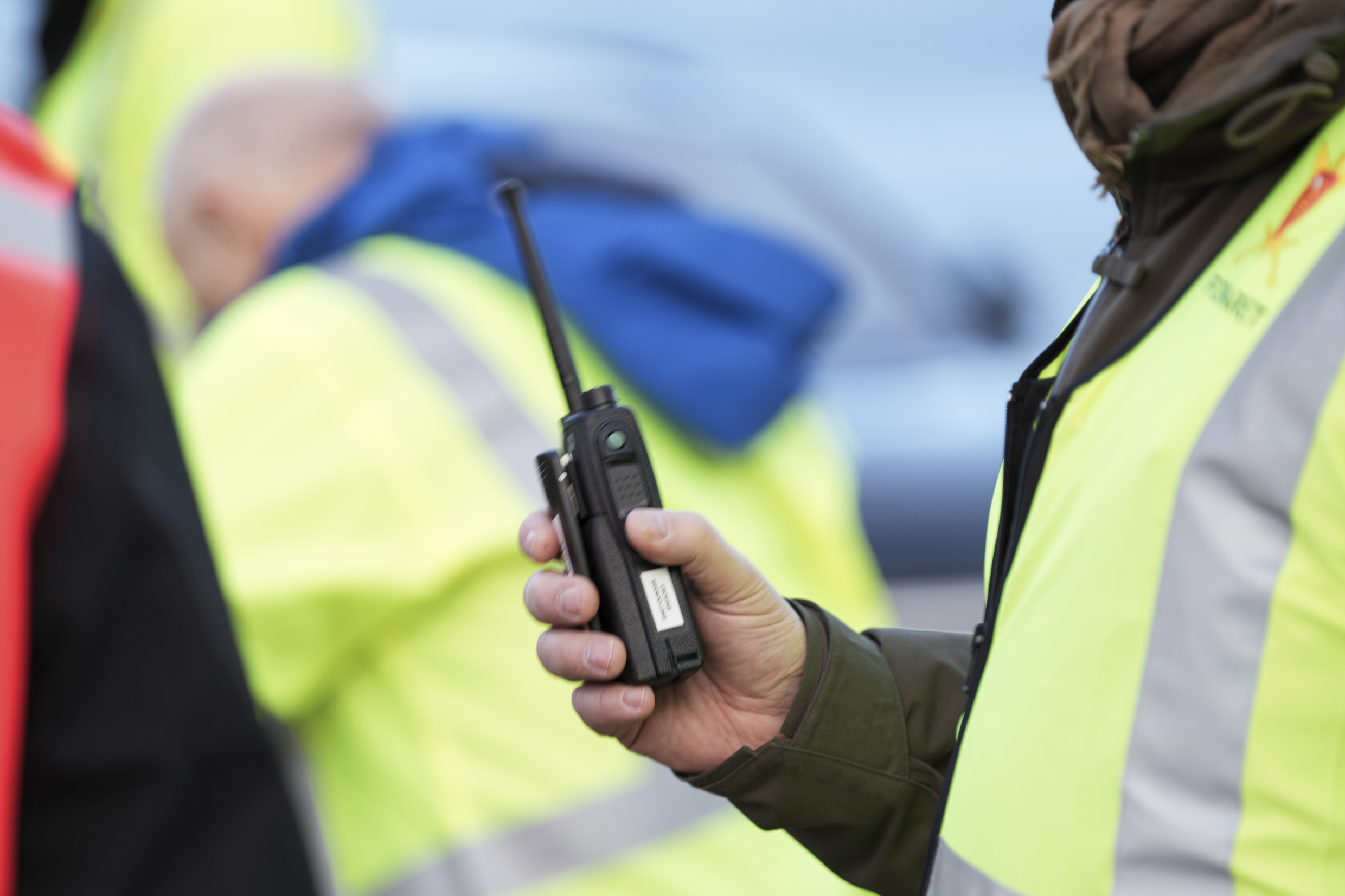 Øvingsdeltakere i refleksvest. En person som holder en nødnett-terminal.