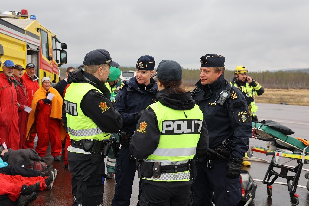 Swedish and Norwegian police in conversation outdoors during exercise