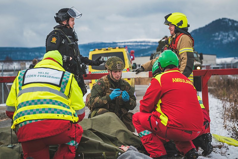 Uniformed emergency services sit around a marker in an exercise