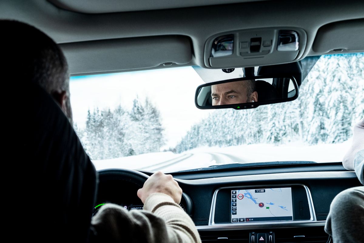 Person som kjører bil med gps i vinterlandskap. 