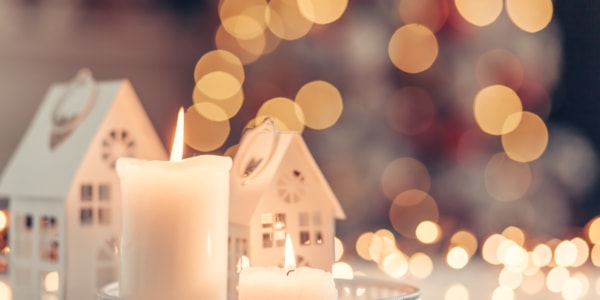 Stearinlys og dekorative gjenstander på et bord. I bakgrunnen lyser det uskarpt.