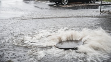 Vann som strømmer opp fra et kumlokk