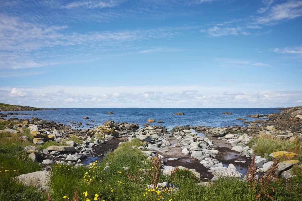 Norskekysten med steinete strand og utsikt over åpent hav