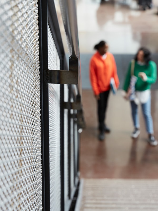 Unge mennesker i uskarpt fokus står i trappegang på skole
