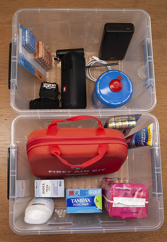 Gjennomsiktige plastkassar med ulikt beredskapsinnhold.