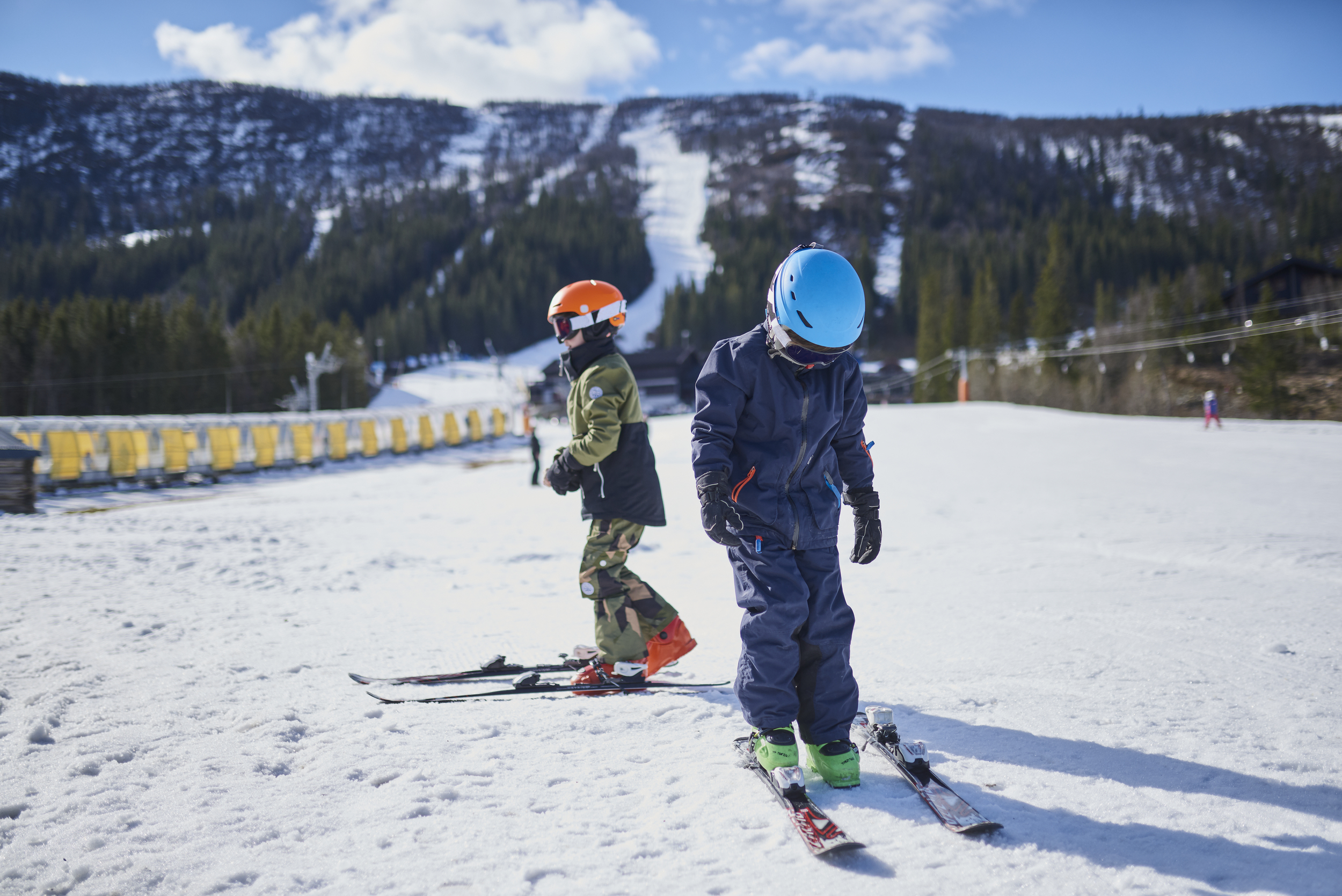 Gutter nederst i skibakke med slalomski, hjelm og briller