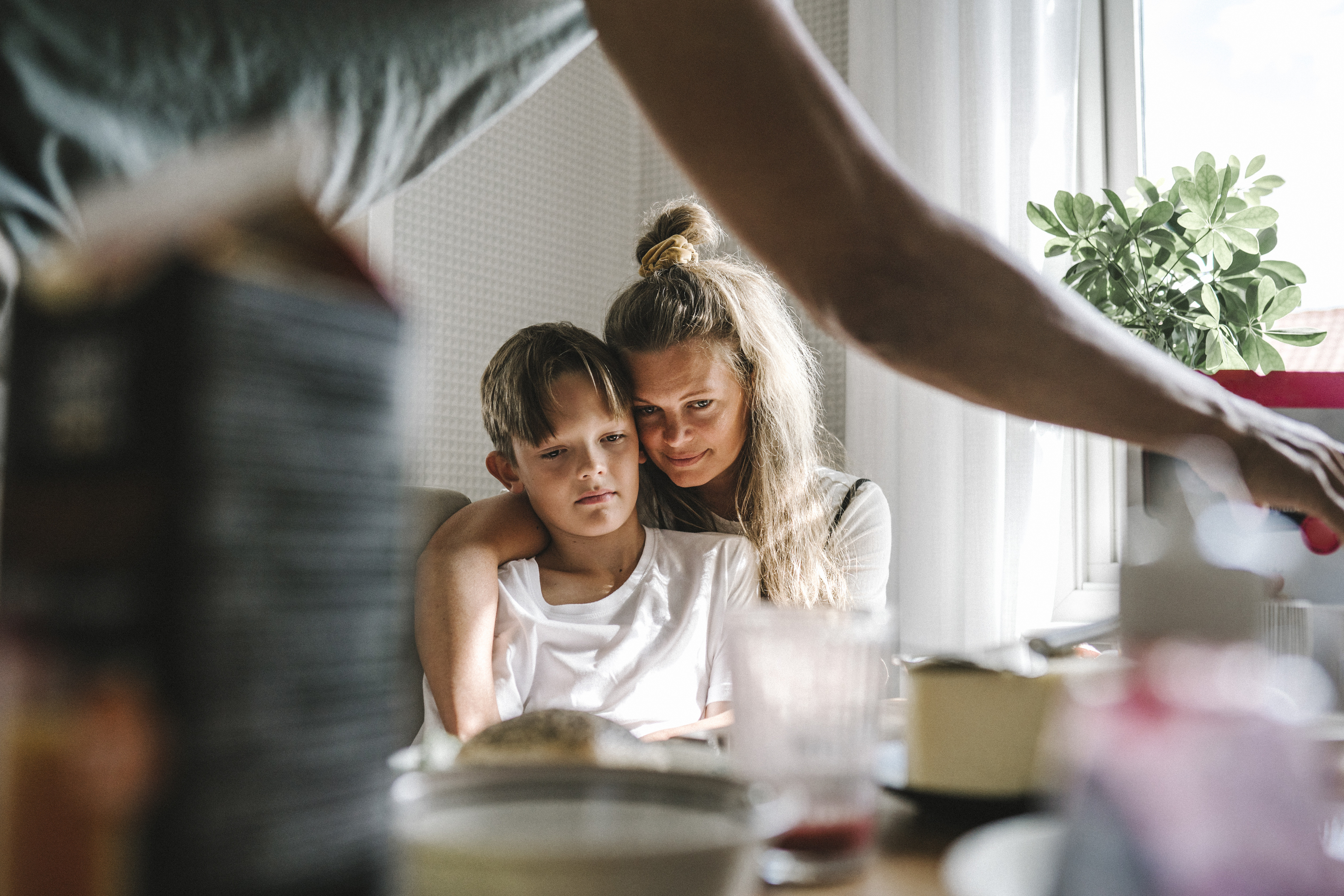 Ung kvinne med stort barn på fanget ved et frokostbord